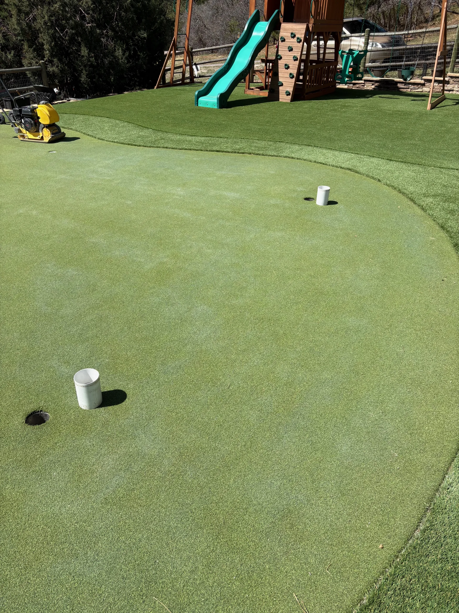Finished residential putting green with two cups in Colorado backyard
