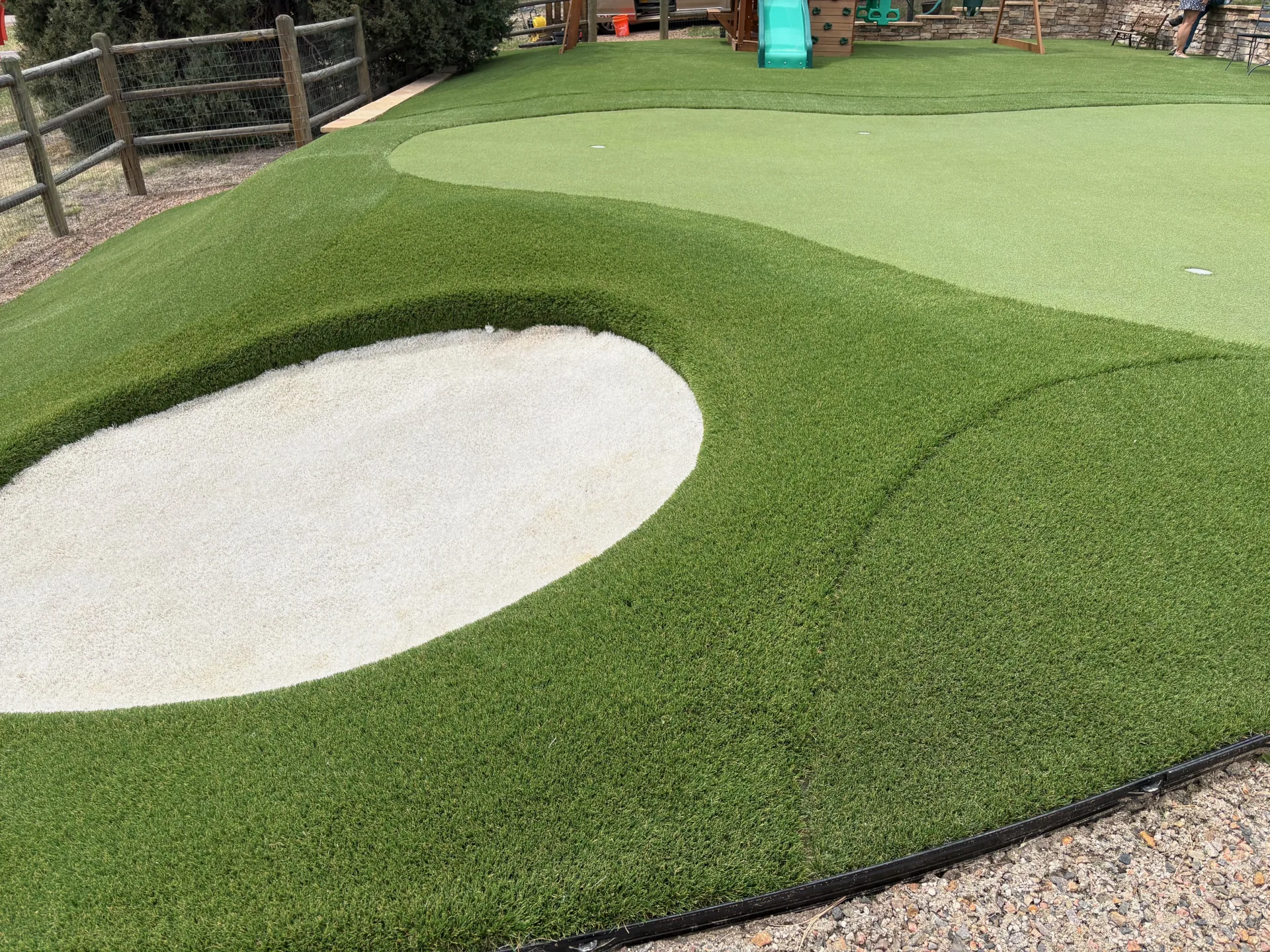 Custom putting green with sand bunker feature in Denver backyard